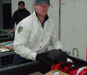 Ranger checks rodent trap in cargo load