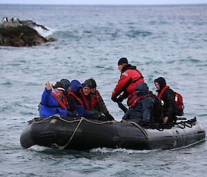 Tourists fill an inflatable rubber boat which is taking them from ship to shore