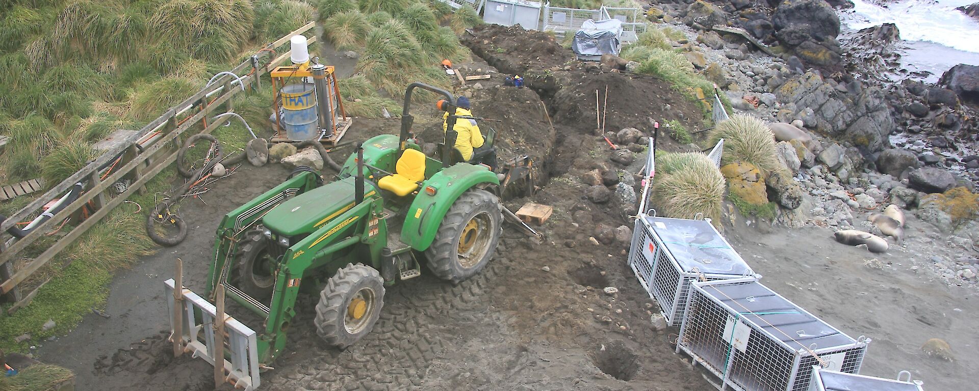 A large excavator ready for work on dirt with water in background