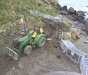 A large excavator ready for work on dirt with water in background