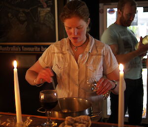 Female expeditoner ladling mulled wine out of a saucepan