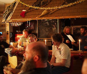 Numerous expeditioners singing carols around the bar