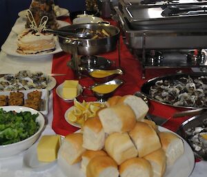 A buffet style Christmas dinner with bread rolls, desserts and the Bain Marie containing the hot dishes