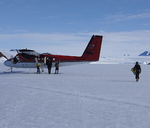 The Director walking towards the Twin Otter on the sea ice before boarding the plane to Davis