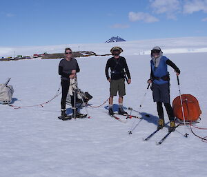 Three expeditioners taking a break after pulling heavily laden sleds across the sea ice