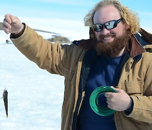 Expeditioner holding up a small fish on his line