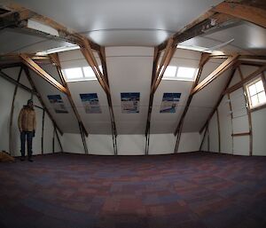 The inside of the hut taken with a fish eye showing teh ceiling beams and carpet tiles on the floor