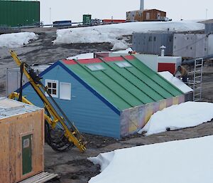 Biscoe has a steeply sloping green roof and at the southern end two carpenters are working