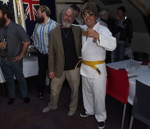 An expeditioner dressed as a Taekwondo master and another expeditioner at the dinner