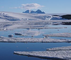 Looking across the ice floes in West Bay with a mountain range rising out of the Antarctic plateau behind