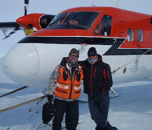 Cliff Simpson and pilot Bob Heath arm in arm in front of a red and white light plane