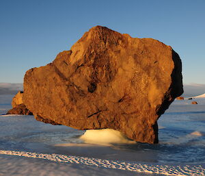 Rock balanced on ice pedestal