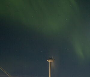 Wind turbine and Aurora Australis in the sky above
