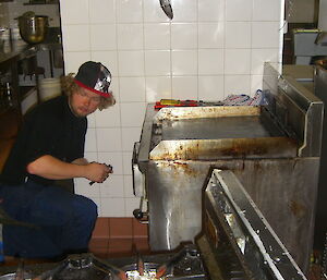 A young male expeditioner is installing a new stove installation