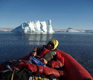 Chris S lies back in an inflatable rubber boat using small navigational equipment