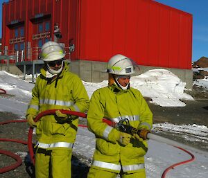 Darron and Chris in uniform directing the high pressure hose at fire exercise