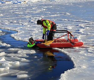 Rescue alive sea ice device being used showing one expeditioner on device pulling another from the icy water