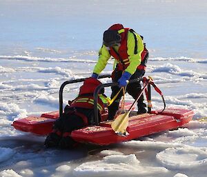 Rescue Alive recovery exercise where one expeditioner is on a small floating device rescuing another expeditioner from icy water