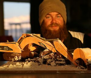Jeremy Little with birthday cake shaped like a CAT excavator