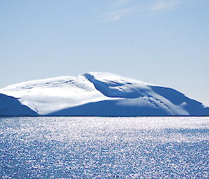 Iceberg on a clear, sunny day surrounded by sparkling water