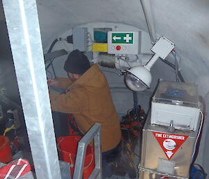 Working in wind turbine, an expeditioner kneels down in a cramped space