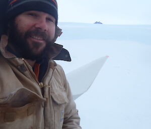 An expeditioner poses at the top of a Mawson wind turbine