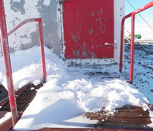 Snow dug out from doorways with red door in background