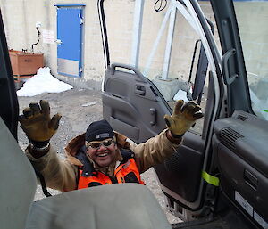 In a photo taken from inside the cab of a Hagg, Cliff Simpson Davis reaches up with both arms from outside to be lifted in