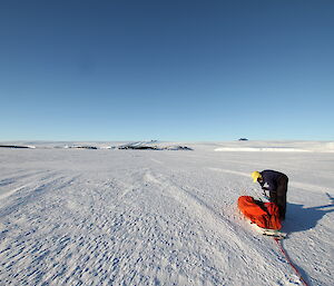 On sea ice off Mawson — lone expeditioner and a sled on al arge expanse of ice