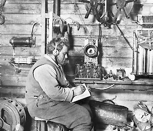Walter Hannam sits at the first radio setup by Australians in Antarctica