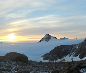 Walking Paterned Lake, two expeditioners are dwarfed by large rocks and expanses of ice