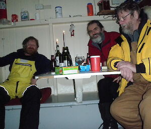 Craig, LLoyd and Darron inside Rumdoodle hut sitting at a table