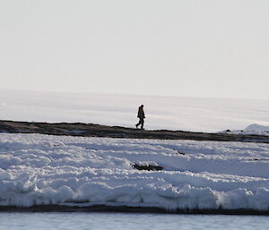 Peter Layt walks across snow in the distance