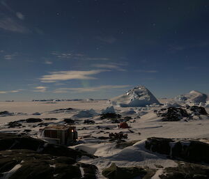 Macey Island huts at night with the icy landscape bathed in moonlight