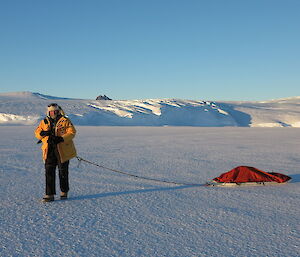 Peter Layt walking on the ice, dragging a small sled