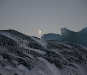 Moon setting behind jade berg