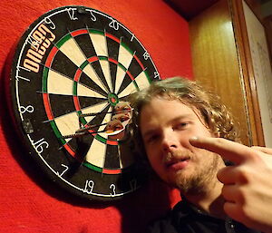 Keldyn pointing at a line of darts in the board
