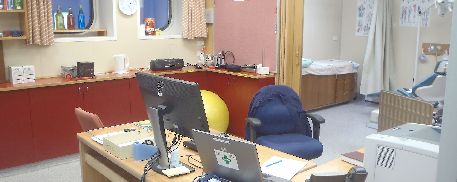 Mawson surgery — a photo of an office with computers on the desk and a doctor’s examination room behind