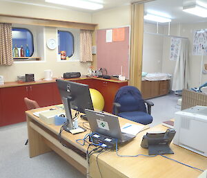 Mawson surgery — a photo of an office with computers on the desk and a doctor’s examination room behind