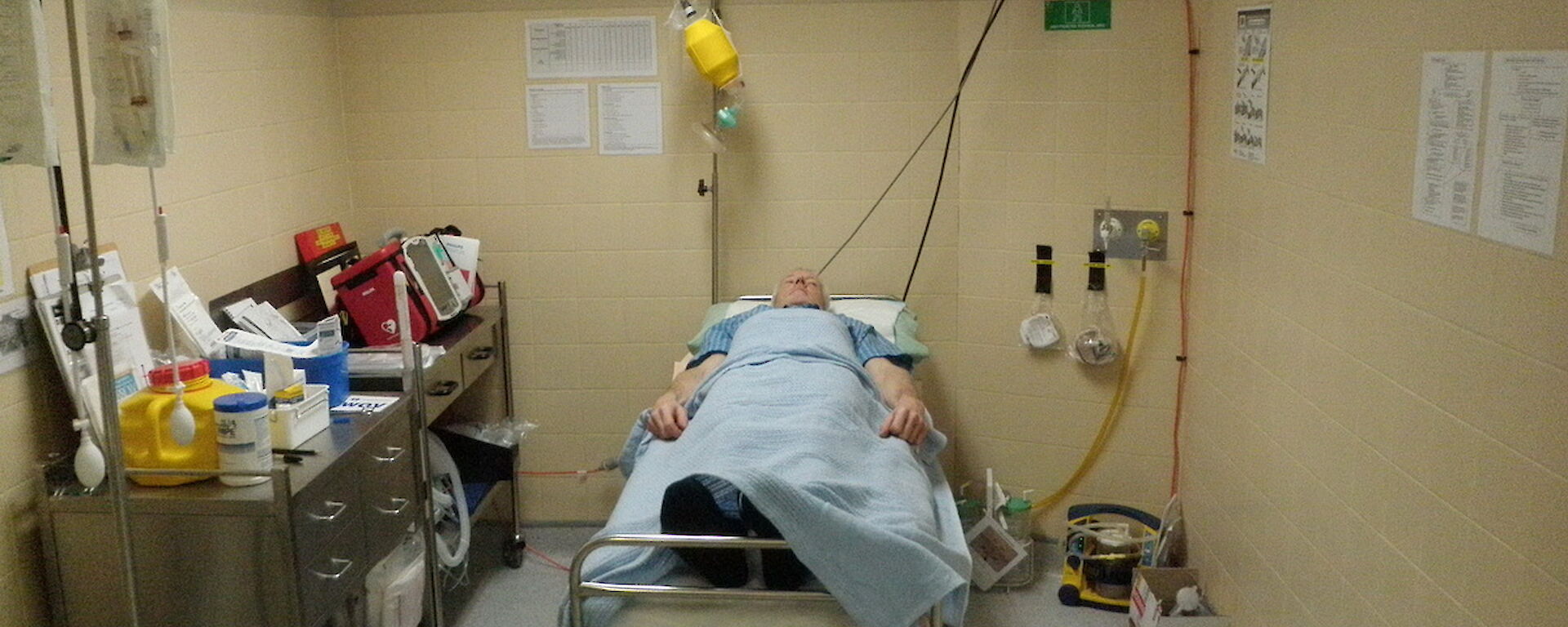 Medical training — a man lies in a hospital bed pretending to be a patient waiting for surgery