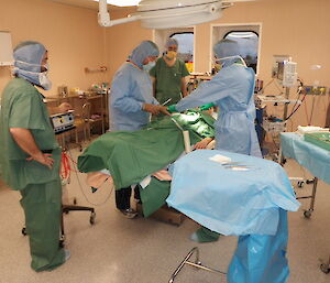 A mock operation that looks like the real thing with medical staff surrounding a pretend patient