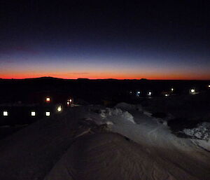 Station skyline showing the station in the foreground and dark but a line of bright orange light on the horizon