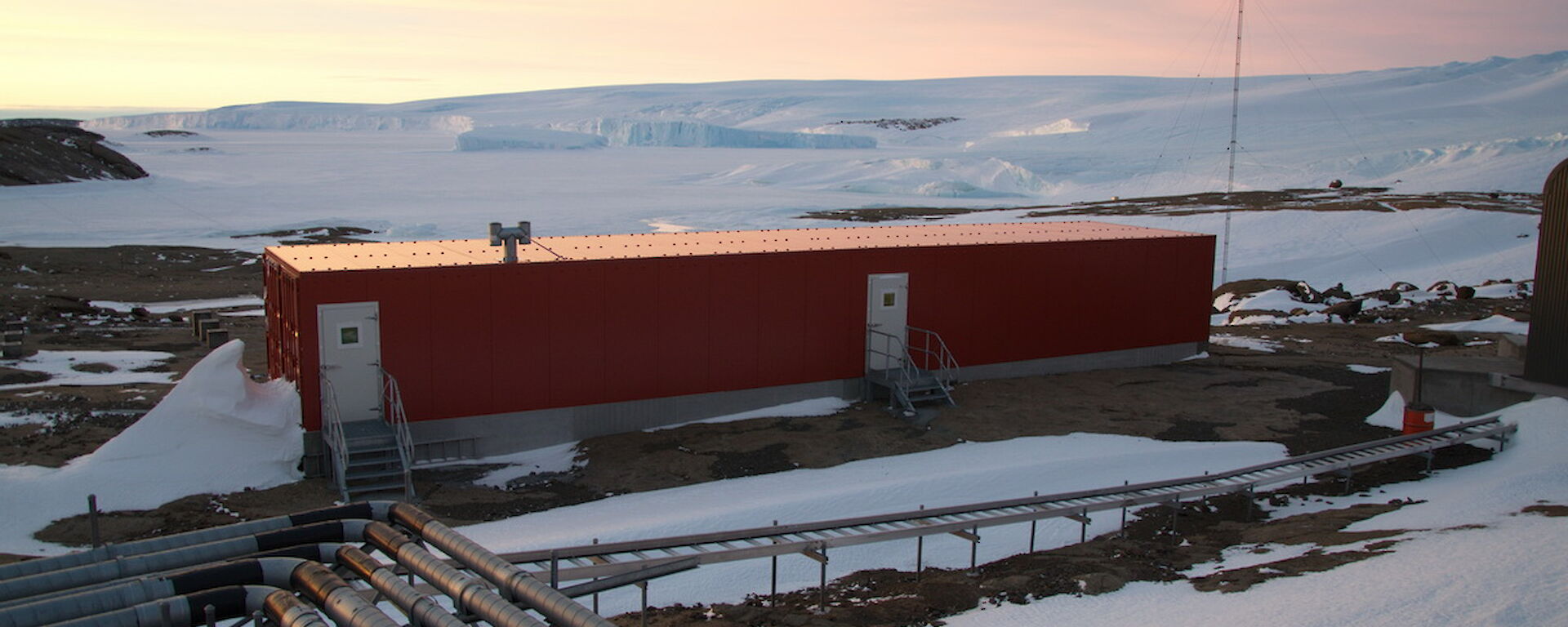 Mawson field store as seen from a distance, surrounded by snow