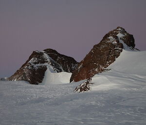 Brown rocky peaks of the South Masson Range are stark against the snow.