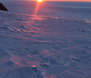 Sun sinking over the horizon of the Mawson coast