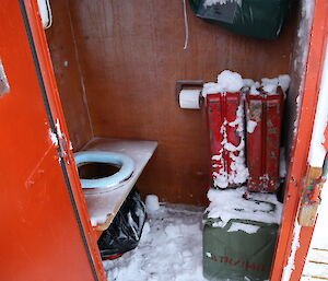 Hut toilet covered in ice and snow