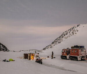 A Hagg is pulled up at Colbeck hut and a tent is pitched nearby.