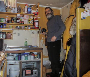 Darron Lehmann wearing thermals by the door inside the hut.