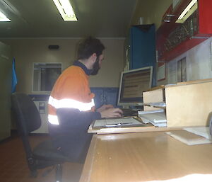 Person sitting at a desk entering information on a computer