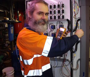 Darron Lehmann standing by a box full of plugs and fuses
